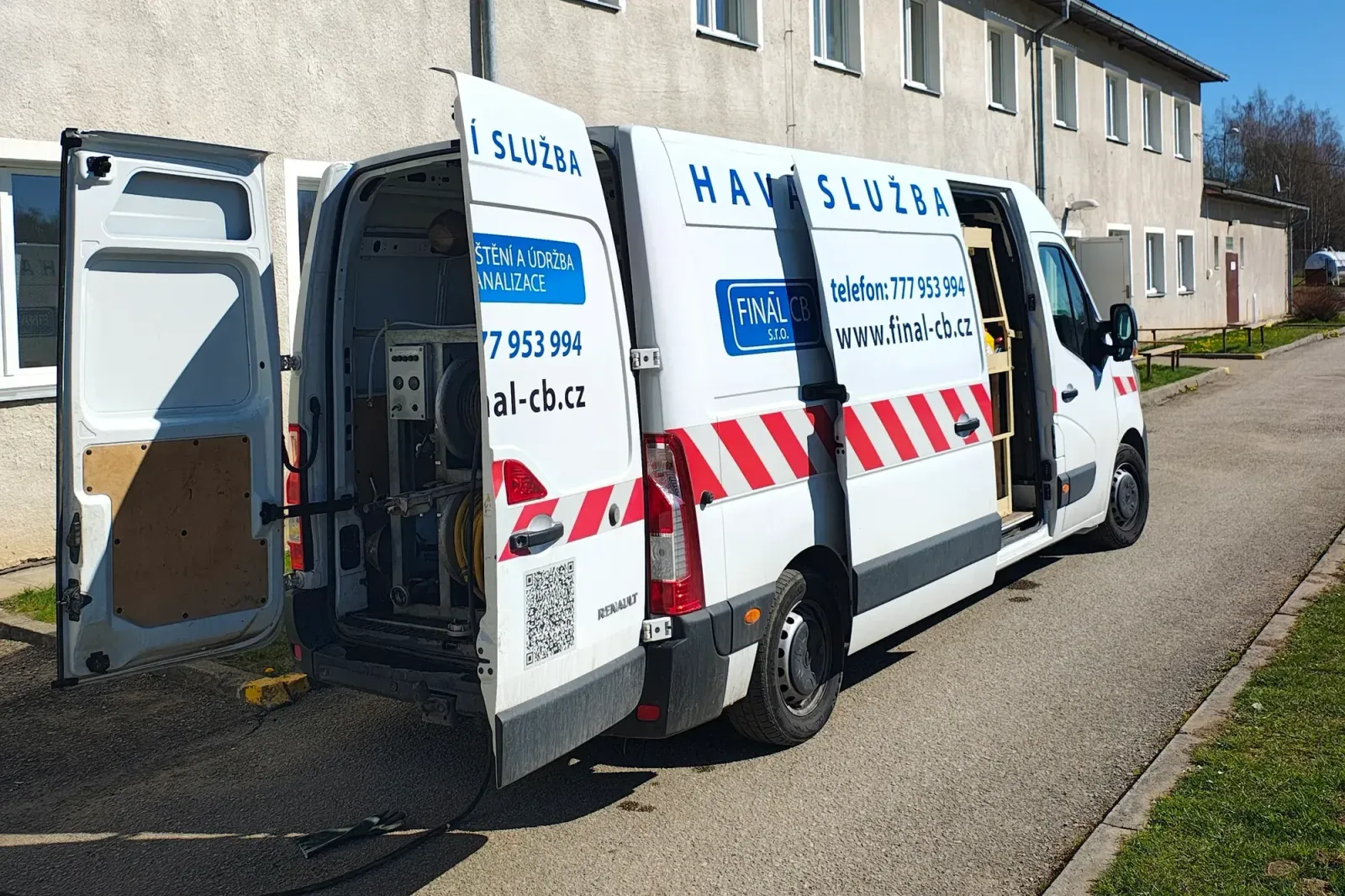 Vůz FINÁL CB s otevřenými dveřmi a technikou pro čištění kanalizace u bytového domu