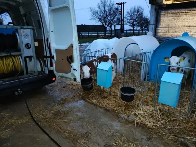 Otevřený vůz FINÁL CB s&nbsp;nataženou hadicí u&nbsp;venkovních boxů pro telata