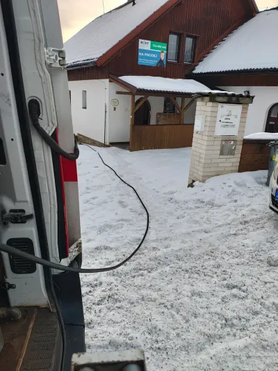 Otevřený vůz FINÁL CB s&nbsp;nataženou hadicí u&nbsp;zasněženého domu