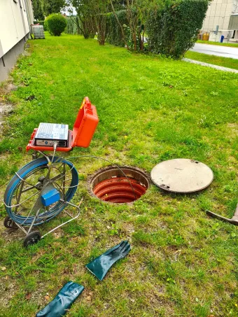 Kamerový vozík, navijáky a&nbsp;nářadí rozložené u&nbsp;otevřené kanalizační šachty