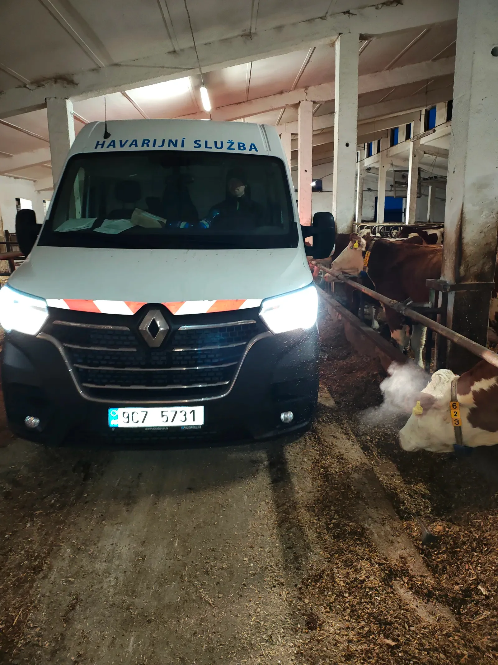 Vůz havarijní služby FINÁL CB s rozsvícenými světly přijíždí do zemědělské haly